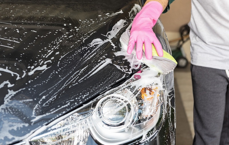 En man tvättar en bil